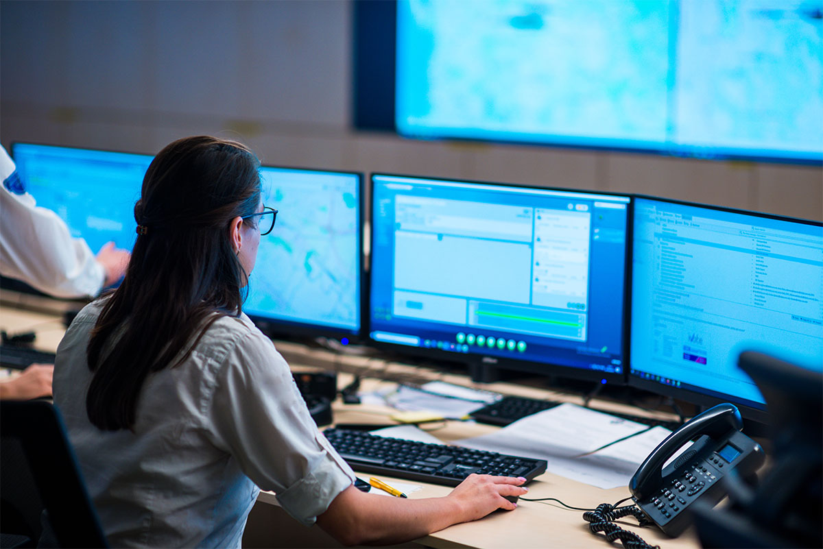 person at desk with multiple computer screens