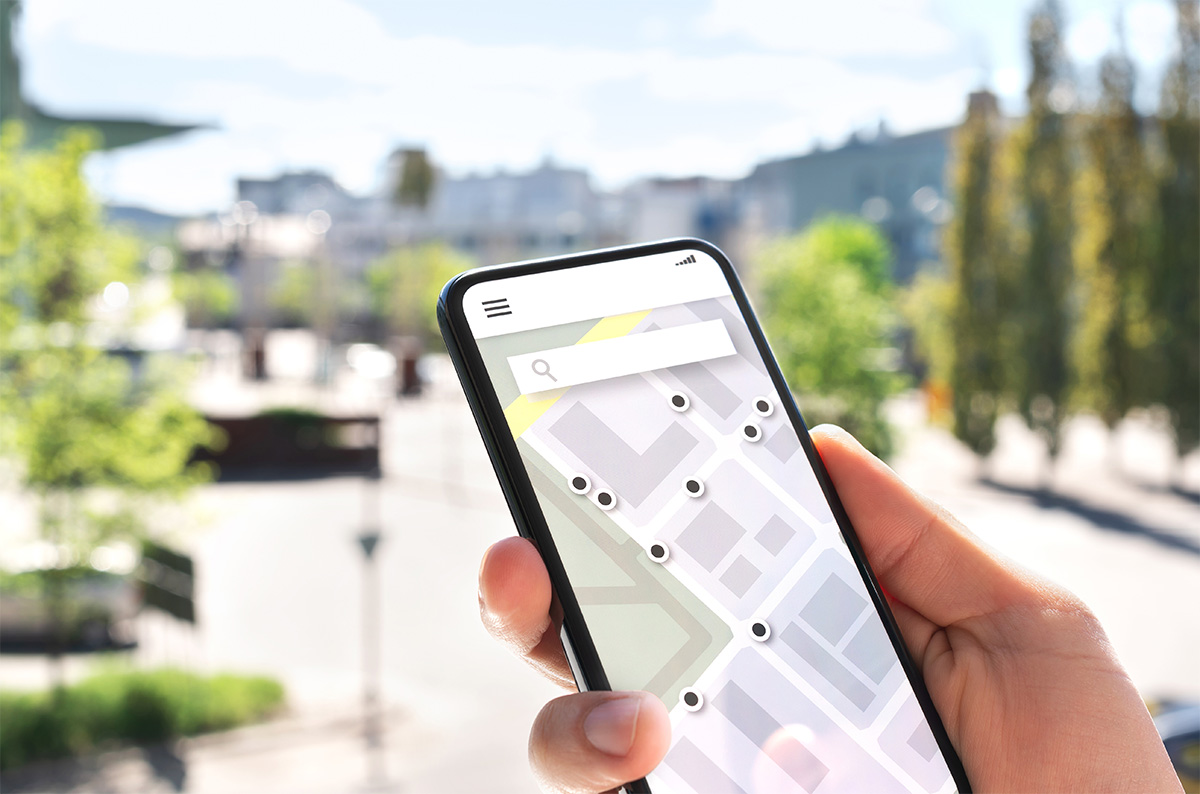 hand holding smart phone with map on screen