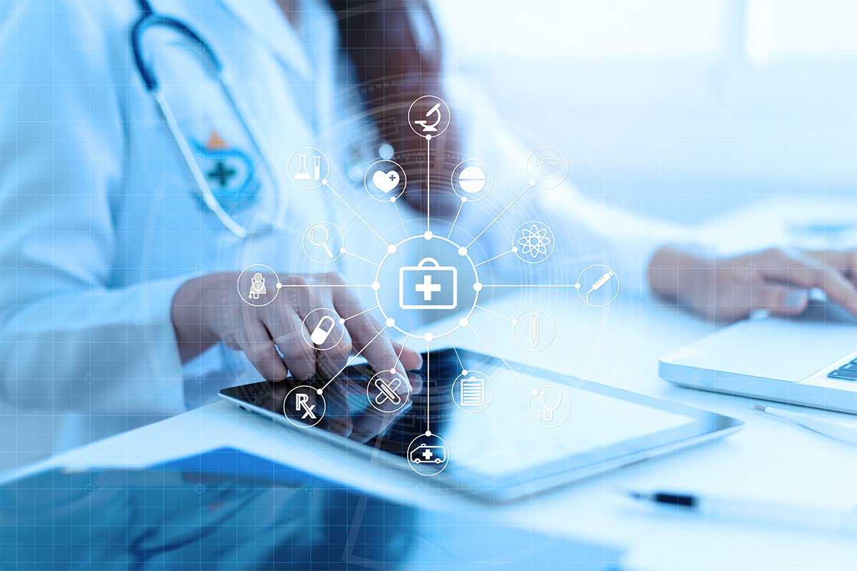 medical professional sitting at desk using smart tablet