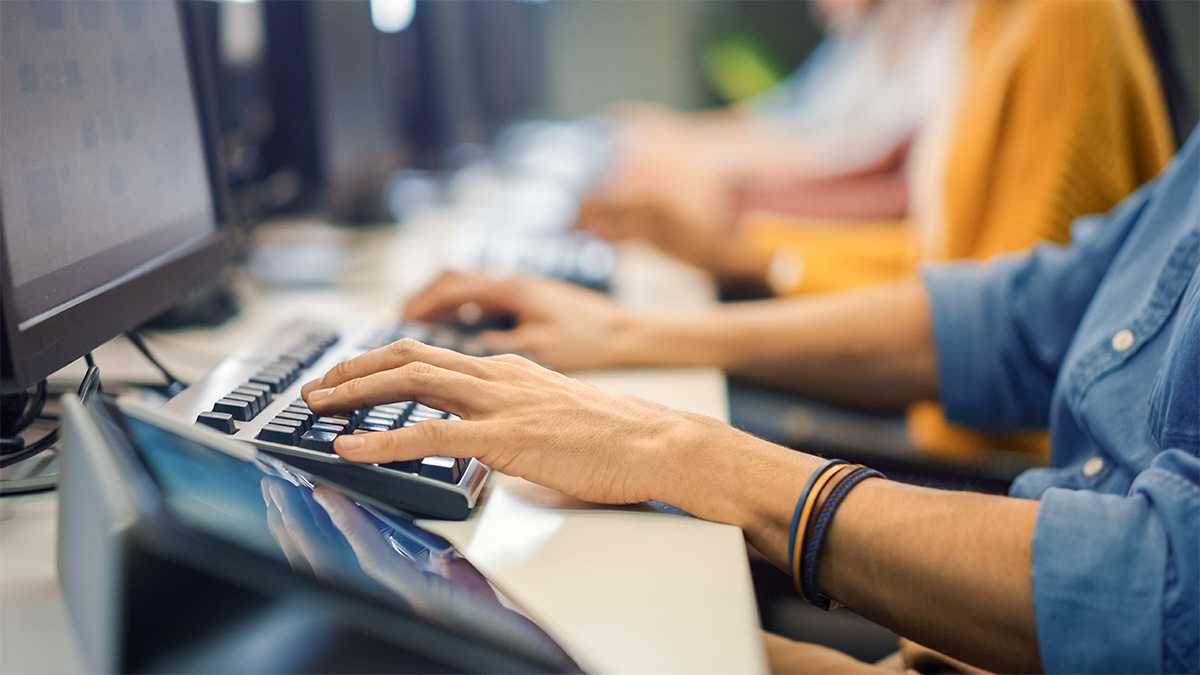 hands at desk typing on keyboard